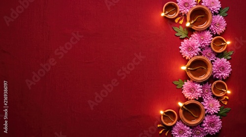 Top view of traditional clay oil lamps with beautiful purple flowers on a deep red background for diwali festival
