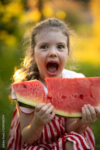 Happy Little Girl Enjoying a Juicy Slice of Ripe Red Watermelon in Summer