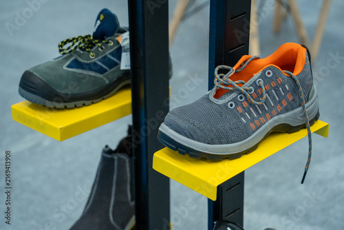 Cuadro en lienzo Work Safety Shoes Displayed On Yellow Shelves In A Store