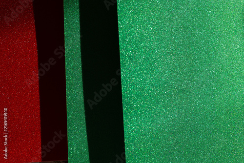 Sparkling red panel framed by green glitter surfaces and a dark divider, providing copy space for Christmas sales, discount announcements, coupons, retail banners and holiday promotions.