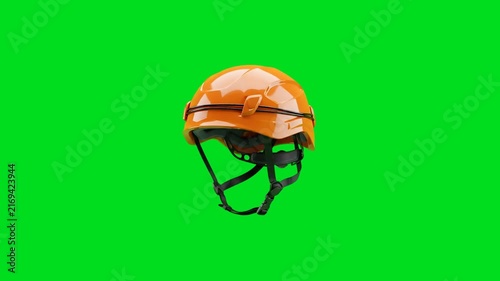 A bright orange industrial safety helmet isolated on a vivid green background