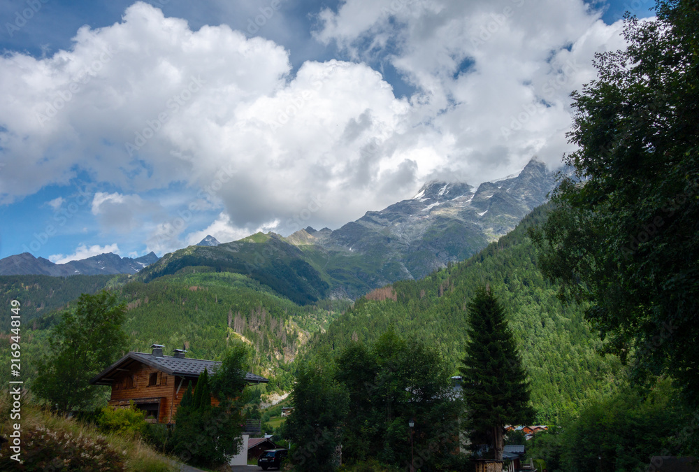 Naklejka premium Wooden chalet in Les Contamines Montjoie under mountain peaks