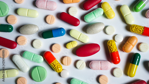 Obraz na plátně pills and capsules are scattered on white surface