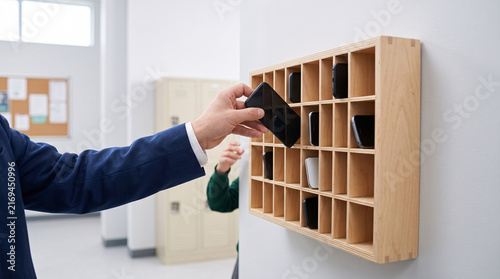 Collecte de smartphones dans un casier à téléphones à l'école