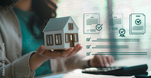 Woman holding house model with certified document icons and compliance checklist overlays for mortgage loan approval