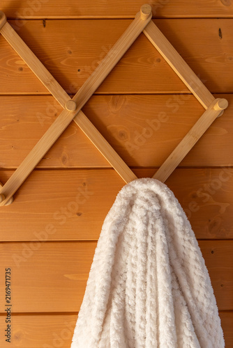 Принти на полотні White bathrobe on wooden peg rack