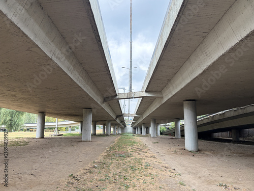 Foto Concrete highway overpass viewed from below with parallel elevated road structur