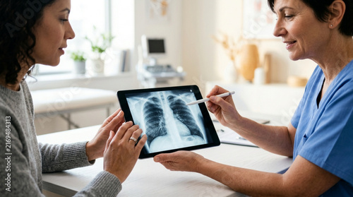 Doctor explains lung X-ray on tablet to patient in clinic