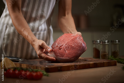 Obraz na płótnie Butcher preparing fresh raw beef for cooking