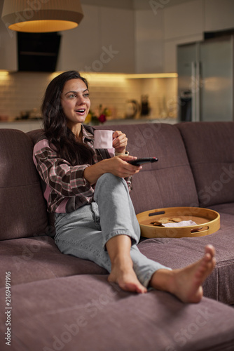Young woman enjoying cozy evening watching tv home