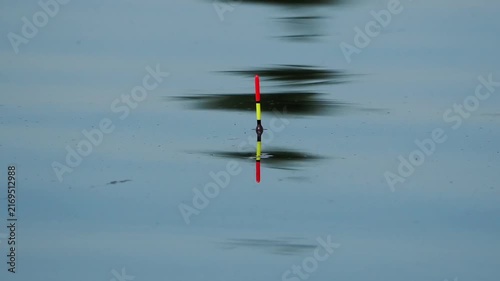 Fishing on a lake. A fishing float bobs on the waves.