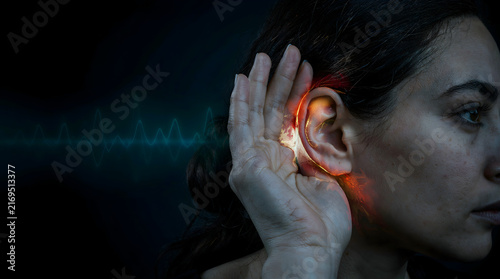 Close-up of a woman feeling discomfort near her ear, illustrating auditory issues or tinnitus