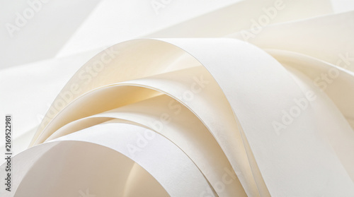 Curling white paper pages forming overlapping curved arches displaying blank unwritten surfaces against bright empty background creating abstract graphic design element macro