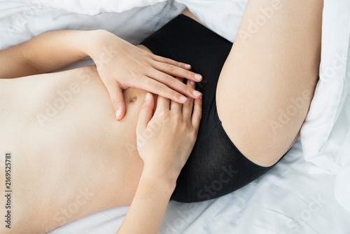 Hands Resting Gently on Abdomen in Bed