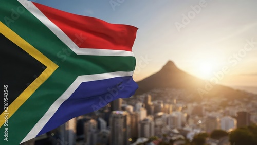 The flag of South Africa waves over the Cape Town cityscape at sunset. A powerful symbol of national pride and South African heritage.