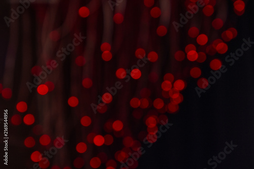 Abstract background of glowing red bokeh lights on a dark background. Festive blurry light circles for Christmas, Valentines Day or party design. Beautiful Christmas or Xmas background bokeh wallpaper