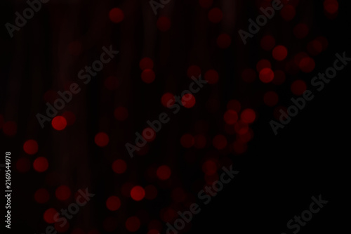 Abstract background of glowing red bokeh lights on a dark background. Festive blurry light circles for Christmas, Valentines Day or party design. Beautiful Christmas or Xmas background bokeh wallpaper