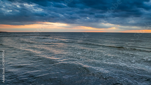 Bild auf Leinwand Gorgeous Polish sea waves lit up by sunset colors.