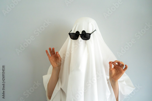 Mysterious white sheet ghost with black sunglasses, funny Halloween character representing coolness, confidence and attitude