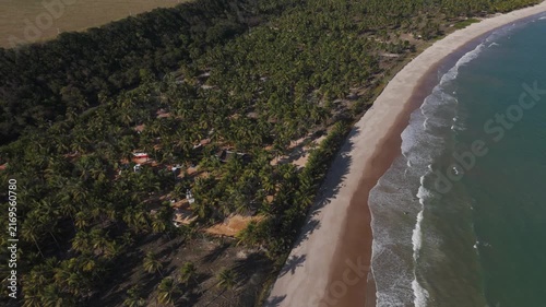 Aerial view of a coastal road crossing dune scrubland toward the open beach