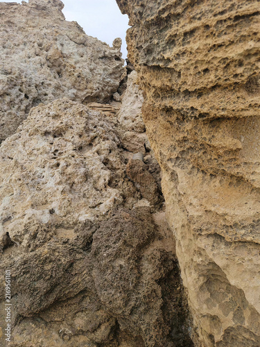 Fotografie Rugged eroded stone surface displays porous layers, cavities and warm earthy tones, creating a detailed geological texture ideal for natural backgrounds, architecture and abstract designs