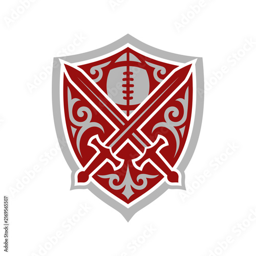 Flat vector logo design of a heraldic shield crest featuring crossed swords and an American football at the top, decorated with intricate grey filigree on a deep red background.