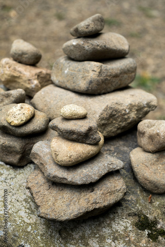 Canvas Print Rock cairn stacks balanced on mossy boulder in forest for zen balance and mindfu