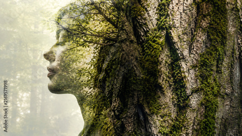 Double exposure portrait blending a serene woman's profile with a moss-covered tree trunk in a misty green forest