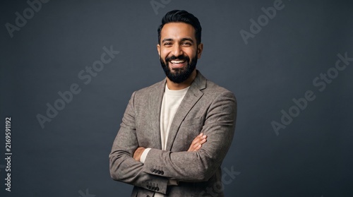 Happy business man CEO looking at camera. Smiling confident 30 years old mature professional businessman executive manager or entrepreneur standing at gray office wall background.
