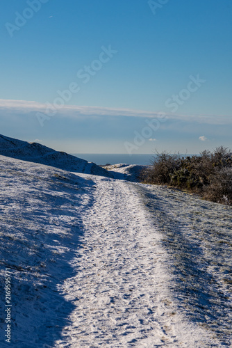 A snowy view in rural Sussex, with the ocean in the distance