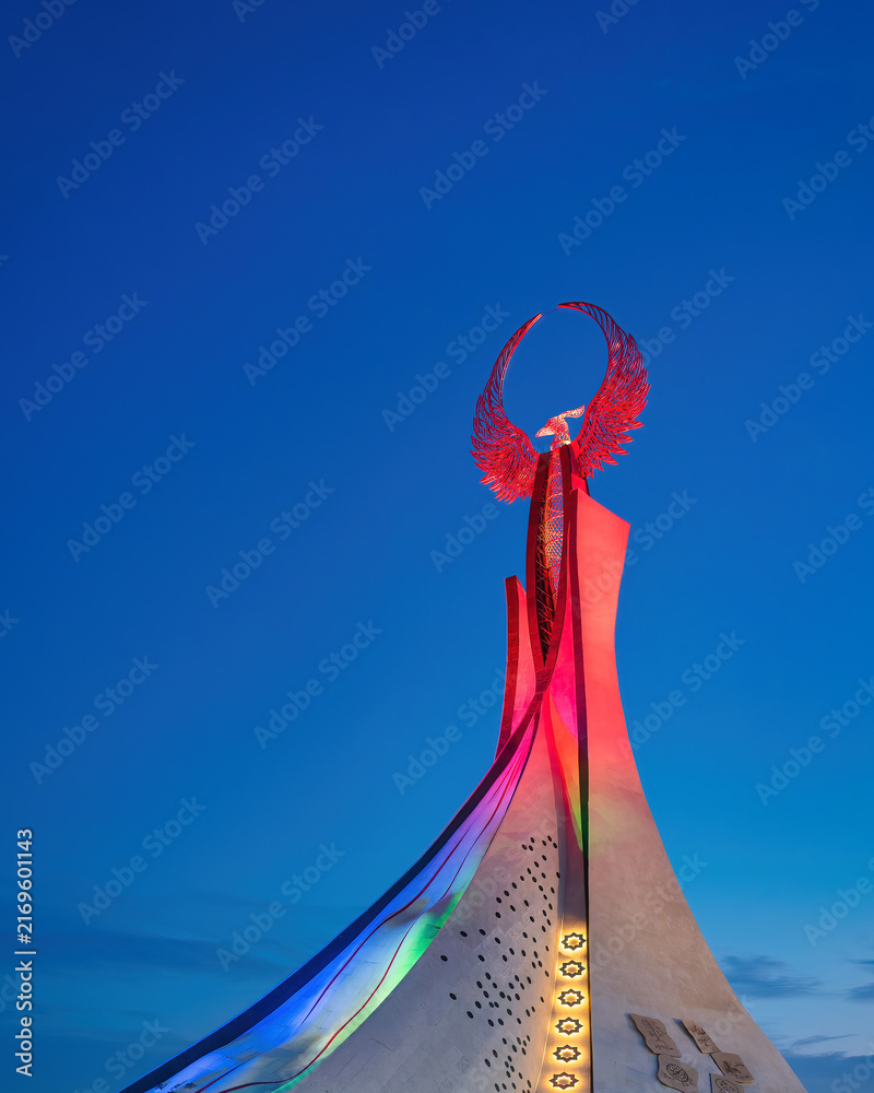 Obraz premium UZBEKISTAN, TASHKENT - JANUARY 4, 2023: Illuminated monument of independence in the form of a stele with a Humo bird in the New Uzbekistan park at night.