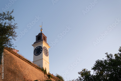 Historic clock tower of Petrovaradin Fortress stands against a clear blue sky. Novi Sad, Serbia