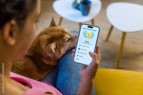 Hispanic Person using an animal health app to manage dog health
