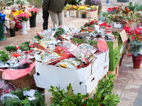 Cardboard boxes full of packed mistletoe twigs and christmas wreaths at outdoor flower market. traditional holiday shopping articles, winter floristry guides or festive sale banners