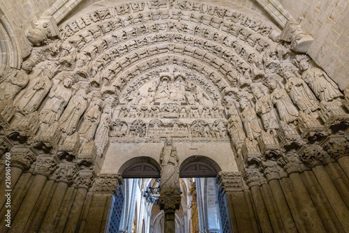 Fotografie An ornate gothic stone portal features intricate sculptural reliefs and religiou