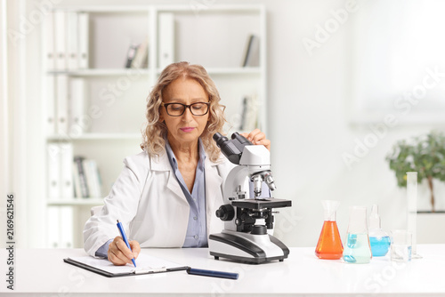 Female scientist doing a research with a microscope