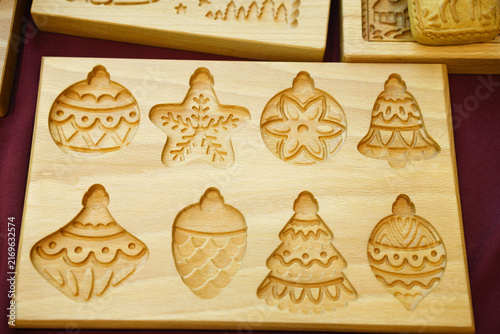 Bild auf Leinwand Carved wooden board with eight christmas cookie shapes including bauble, snowfla