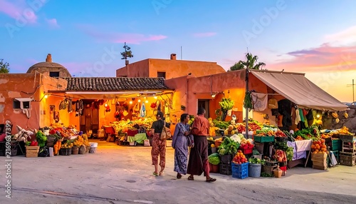 People walking through a vibrant Moroccan street market at sunset.