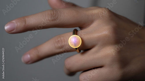 Closeup of a glowing iridescent pearl ring on a womans finger