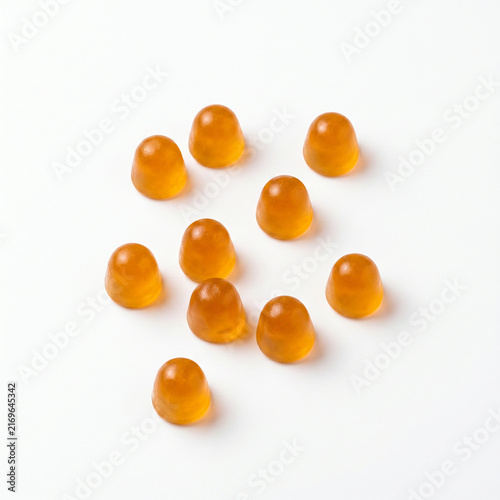 Yellow gummy vitamins dietary supplement isolated on white background. Macro shot of chewable jelly candies.