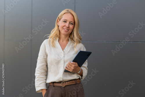 Cuadro en lienzo Confident business woman holding digital tablet outdoor