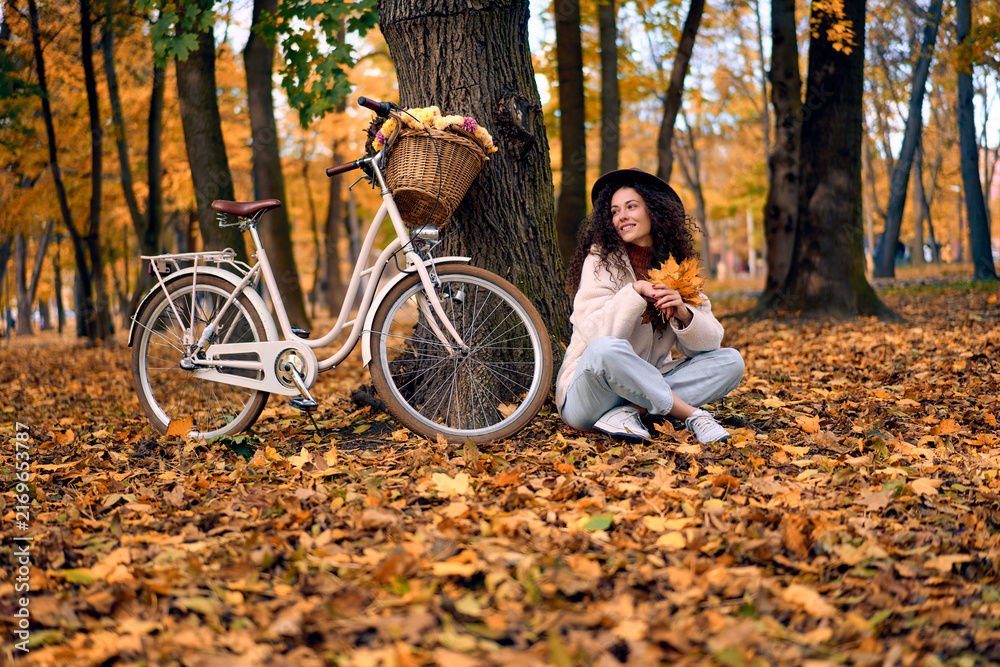 Naklejka premium Woman with bicycle in autumn forest.