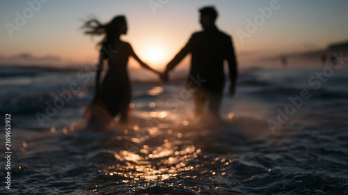 Couple Holding Hands Walking in Ocean at Sunset