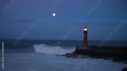 Moonlit Lighthouse Guiding Ships Through Stormy Sea at Dusk