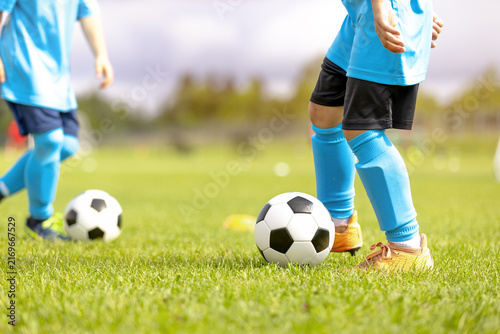Close-Up of Junior Soccer Players in Light Blue Kits Dribbling Soccer Balls - Youth Football Training Drill and Ball Control Practice on Grass