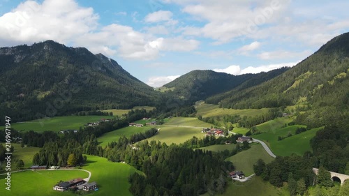 Aerial drone view of the idyllic Bavarian Alps near Ramsau bei Berchtesgaden, Germany, featuring lush green alpine meadows, narrow country roads and majestic mountain scenery. Peaceful rural footage