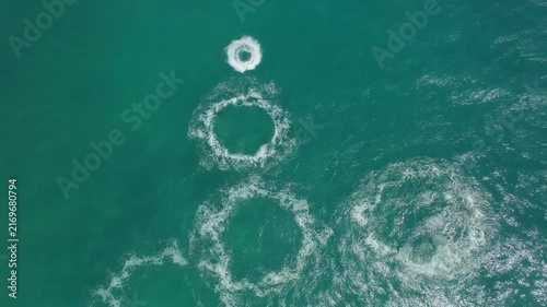 Aerial Top-Down View of Turquoise Water with White Foam Patterns and a Floating Ring