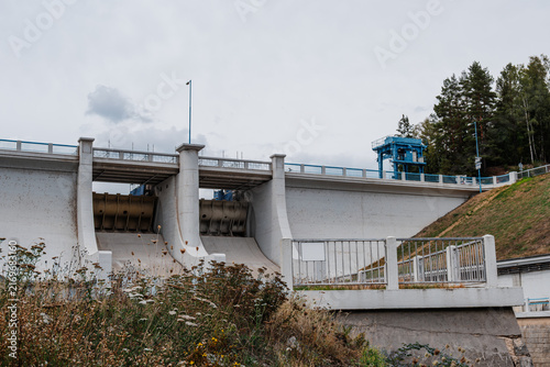 Bild auf Leinwand A large concrete hydroelectric dam and spillway with hydraulic gates, access structures and control equipment, representing modern water management and civil engineering