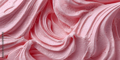 Closeup of swirled pink cream or frosting with smooth glossy texture.