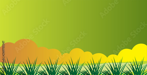 Warm sunset background with colorful orange clouds and sharp dark green grass silhouettes for dramatic nature backdrop.